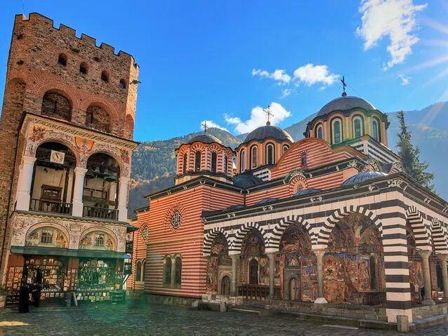 A view of Rila Monastery's colorful main church and tower against blue sky