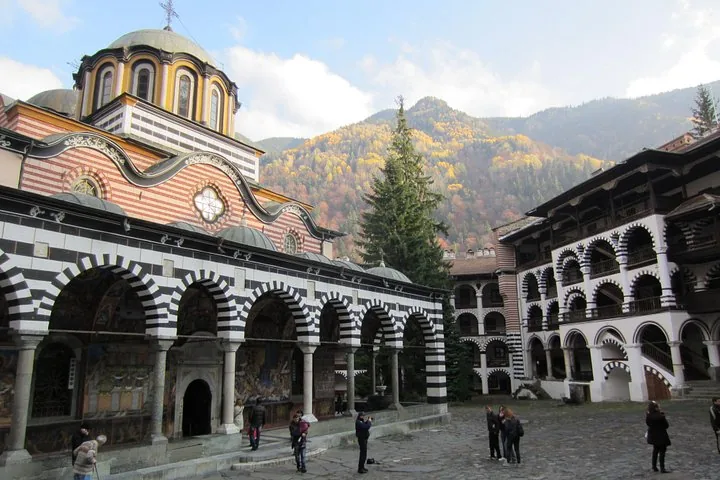 Rila Monastery courtyard with the main church, residential wings, and autumn mountain backdrop
