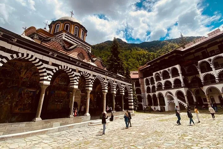 Tourists walking in the central courtyard of the historic Rila Monastery complex