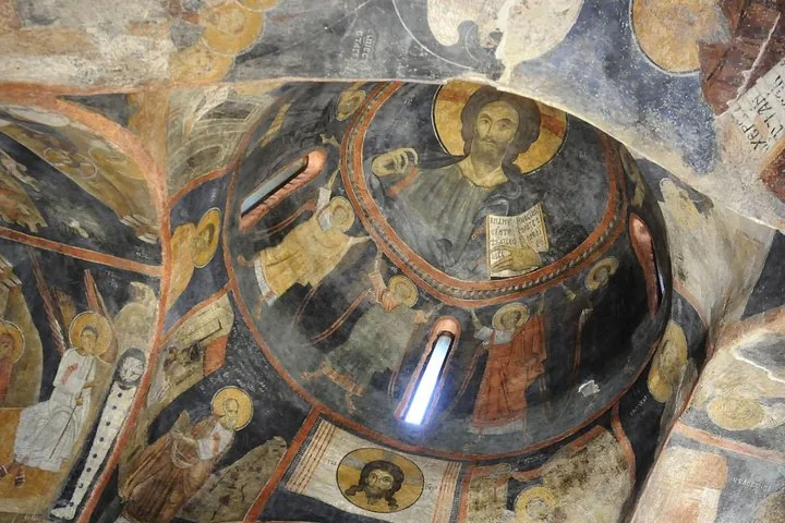 Interior dome view showcasing ancient religious frescoes inside a historic church